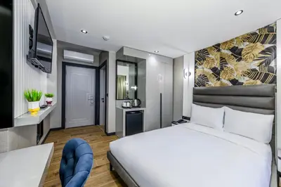 a bedroom with a white bed and a tv at Dedem Hotel Premium - Çorlu in Corlu