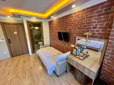 a brick walled room with a bed and a sink at Meydan Suites in Istanbul