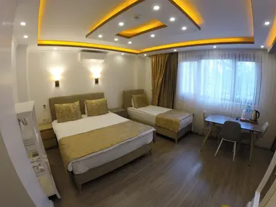 a hotel room with two beds and a desk at Meydan Suites in Istanbul