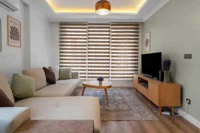 a living room with a couch and a tv at Luxury Scandinavian Design 2BR Duplex Near Tomtom in Istanbul