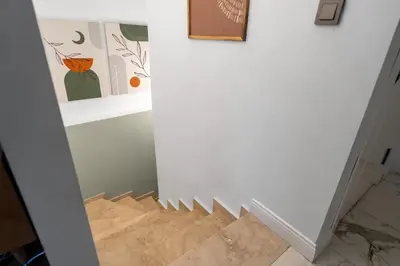 a hallway with a staircase with art on the wall at Luxury Scandinavian Design 2BR Duplex Near Tomtom in Istanbul