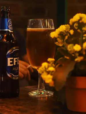 a glass of beer sitting next to a beer bottle at Obishu in Istanbul