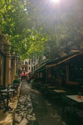a street with tables and chairs and the sun shining at Obishu in Istanbul