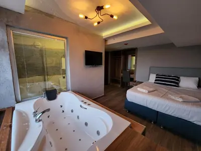 a bathroom with a bath tub and a bed at Martin City Hotel in Bursa