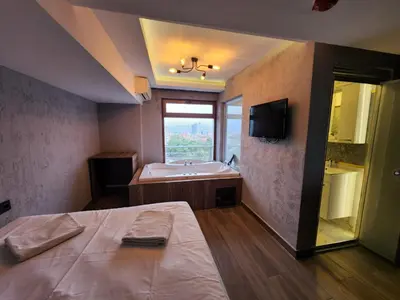 a bathroom with a tub and a bed and a sink at Martin City Hotel in Bursa