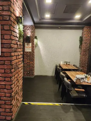 a dining room with a brick wall and tables and chairs at Martin City Hotel in Bursa