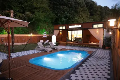 a swimming pool in a yard with chairs and a house at The Jungle Sapanca in Sakarya