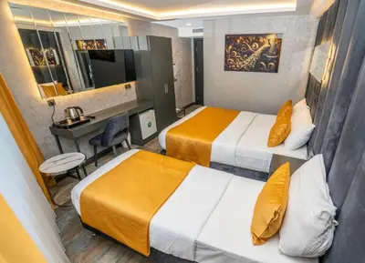 a hotel room with two beds and a desk at 216 Silver Suite in Tuzla