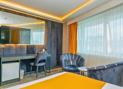 a room with a desk and two chairs and a table at 216 Silver Suite in Tuzla