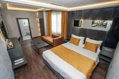 a hotel room with a large bed and a chair at 216 Silver Suite in Tuzla