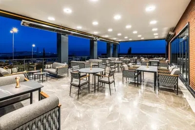 a restaurant with tables and chairs with a view at GOLDEN TULIP GEBKIM KOCAELI in Kocaeli