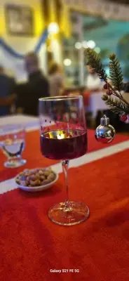 a wine glass on a red table with a plate of food at Çakıl Restoran ve Bungolov in Silivri