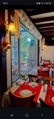 a dining room with red tables and a large window at Çakıl Restoran ve Bungolov in Silivri