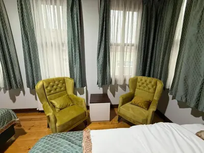 a bedroom with two chairs and a bed and windows at Grand Bedir in Istanbul