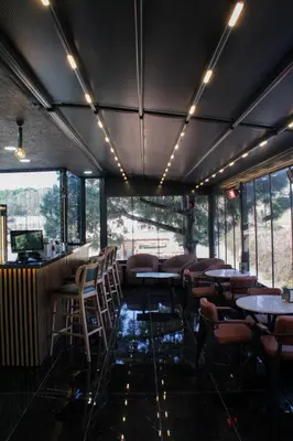 a restaurant with tables and chairs in a room with windows at Bohem Hotel in Beykoz