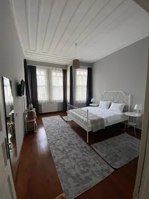 a white bedroom with a bed and a rug at DESTA Turizm in Istanbul