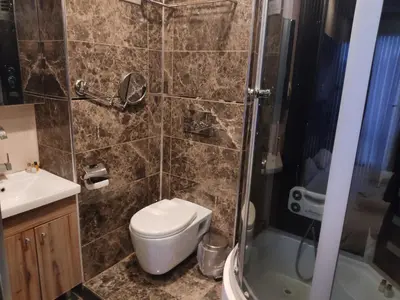 a bathroom with a shower and a toilet and a sink at AG Hotel & Residence Şişli in Istanbul