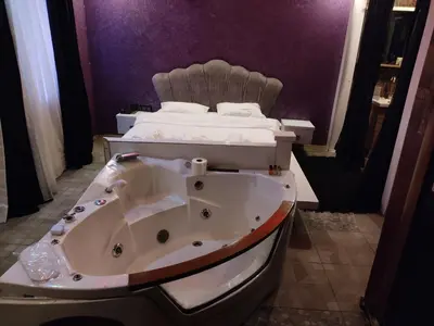 a bathroom with a bath tub and a bed at AG Hotel & Residence Şişli in Istanbul