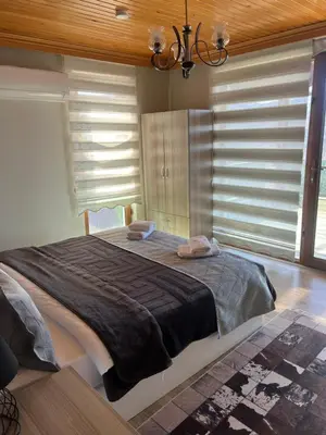 a bedroom with a large bed in a room with windows at Montana butik pansiyon in Sapanca