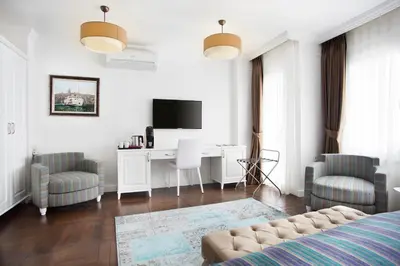 a bedroom with a bed and a desk and a tv at Astan Hotel Taksim in Istanbul