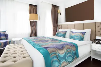 a bedroom with a large bed with a colorful blanket at Astan Hotel Taksim in Istanbul