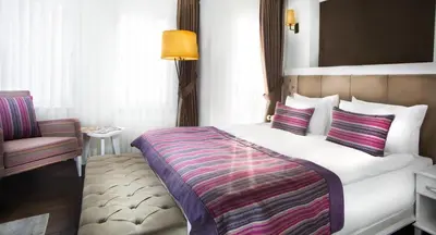 a hotel room with a bed and a chair at Astan Hotel Taksim in Istanbul