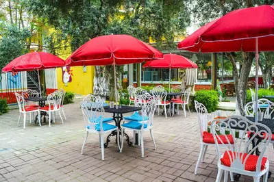 a group of tables and chairs with red umbrellas at İznik Seyir Otel in İznik