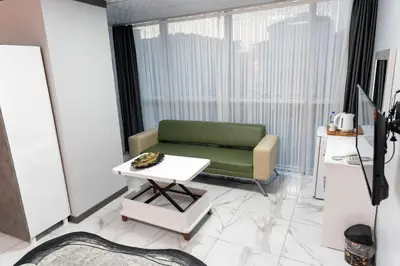 a living room with a green couch and a table at Merkez Otel in Cerkezkoy