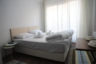 a bedroom with a bed with white sheets and a window at Studios & Balat in Istanbul