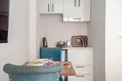 a kitchen with a table and two blue chairs at Studios & Balat in Istanbul
