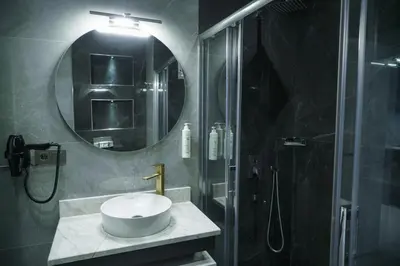 a bathroom with a sink and a shower with a mirror at Elite World Homes Istanbul Bosphorus in Istanbul