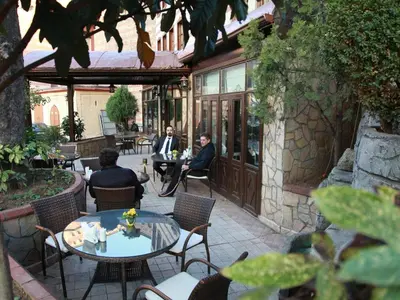 a group of people sitting at tables on a patio at Kadi Konagi Thermal Hotel in Bursa