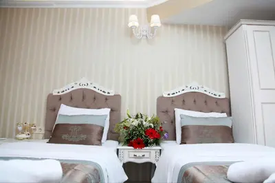 a bedroom with two beds and a vase of flowers at Kadi Konagi Thermal Hotel in Bursa
