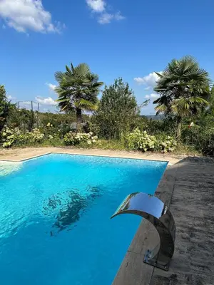 a blue swimming pool with a metal object next to it at Nerry's Garden Izmit - Rose in Yukarı Mecidiye