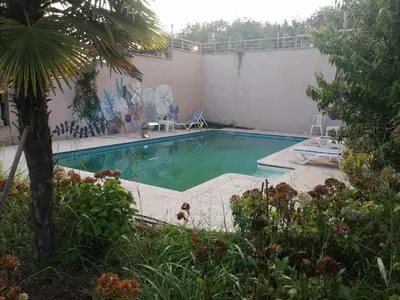 a large swimming pool in a yard with plants at Nerry's Garden Izmit - Rose in Yukarı Mecidiye