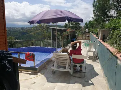 a girl sitting in a chair next to a swimming pool at Nerry's Garden Izmit - Rose in Yukarı Mecidiye