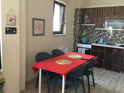 a kitchen with a red table and chairs in a room at Nerry's Garden İzmit - Camellia in Izmit