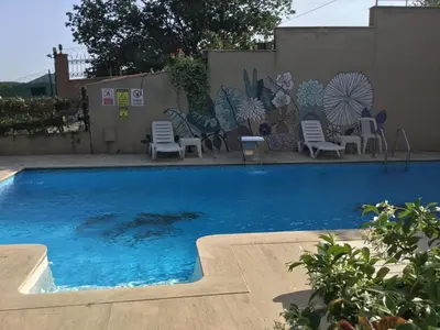 a swimming pool with chairs and a wall with a mural at Nerry's Garden İzmit - Camellia in Izmit