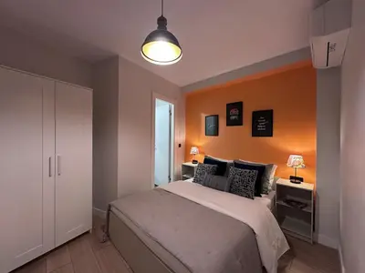 a bedroom with a bed with an orange wall at Stunning 2BR 2Bath near Metro - YM 1 in Istanbul
