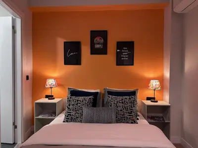 a bedroom with a bed with an orange wall at Stunning 2BR 2Bath near Metro - YM 1 in Istanbul