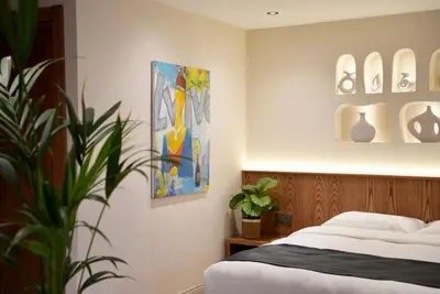 a bedroom with a bed and a painting on the wall at Khalkedon Suites in Istanbul