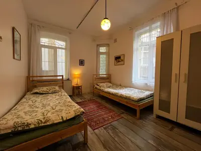 a bedroom with two beds and two windows at Taksim Apartment in Istanbul
