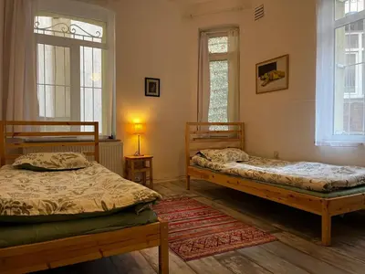 two beds in a room with two windows at Taksim Apartment in Istanbul
