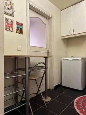 a small kitchen with a table and a refrigerator at Roza's Istanbul Homestay in Istanbul