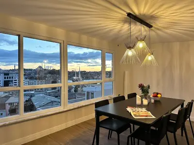a dining room with a table and chairs and windows at Stunning Seaview 2BR near Metro - YM4 in Istanbul