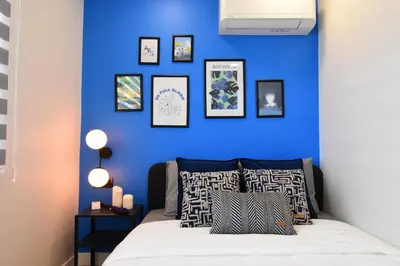a bedroom with a blue wall with a bed with pillows at Stunning Seaview 2BR near Metro - YM5 in Istanbul
