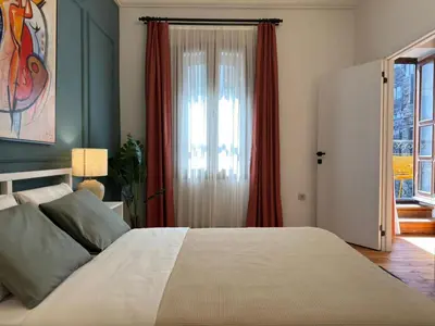 a bedroom with a bed with red curtains and a window at Taksim Square - Unique Loft for 12 Guests in Istanbul