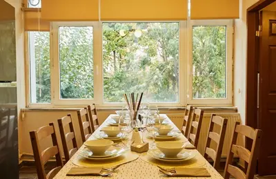 a dining room with a table with chairs and two windows at Stunning 3BR 3Bathroom 3AC near Metro D1 in Istanbul