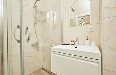 a white bathroom with a sink and a shower at Stunning 3BR 3Bathroom 3AC near Metro D1 in Istanbul