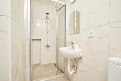 a white bathroom with a sink and a shower at Stunning 3BR 3Bathroom 3AC near Metro D1 in Istanbul
